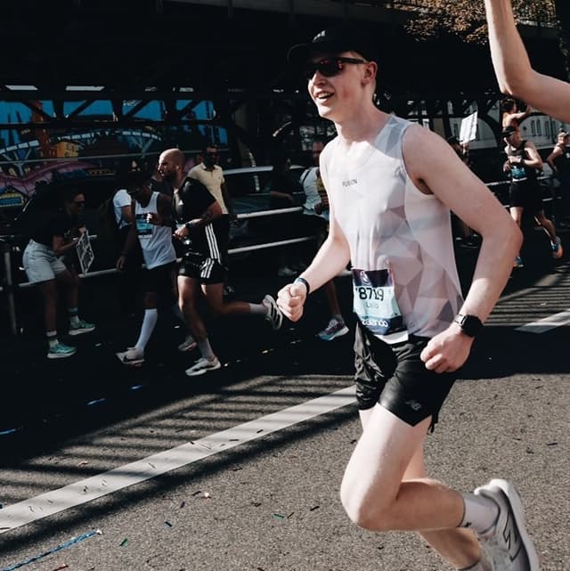 A runner participates in a marathon event, smiling under sunny conditions.