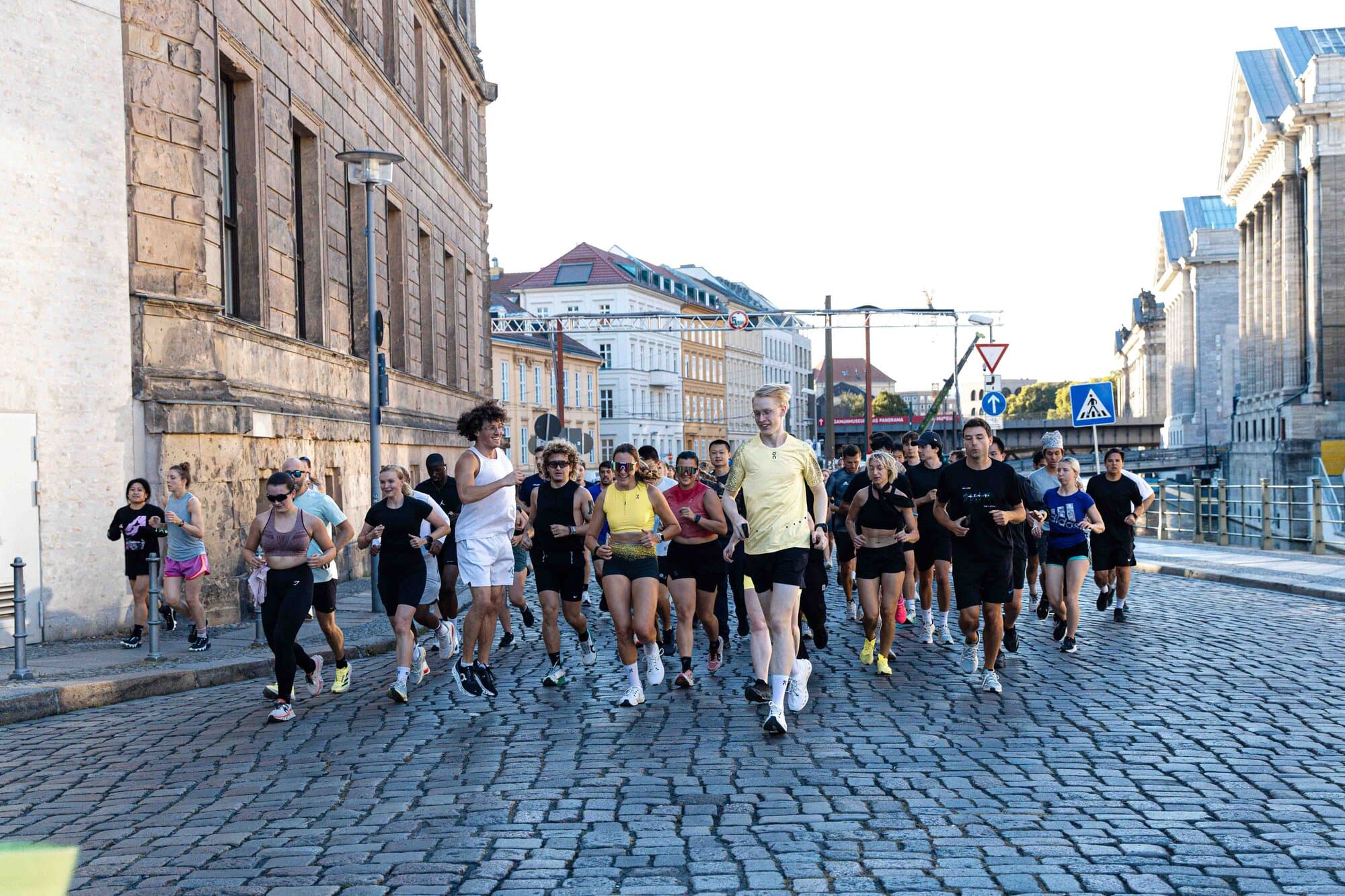 A group of people jogging together on a city street.